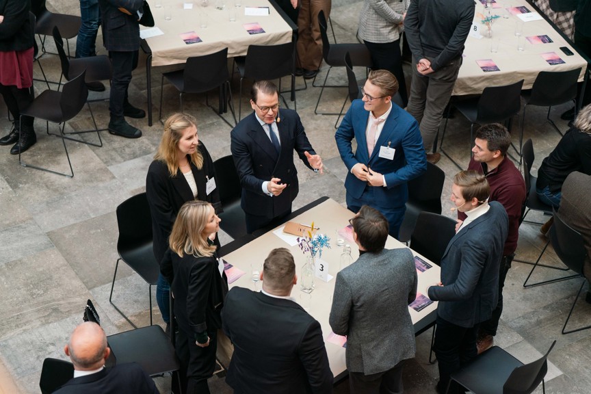personer st&aring;ende runt bord